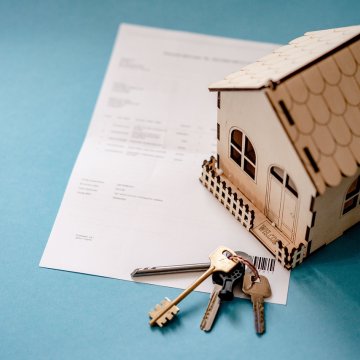 Real estate agreement with small house and keys on a table